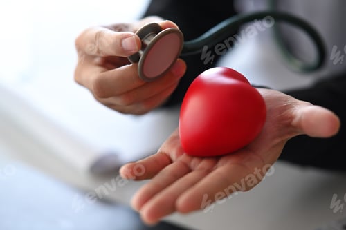 Preview: Close up doctor holding red heart and stethoscope. Health insurance concept