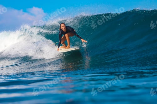 Preview: Female surfer on a blue wave