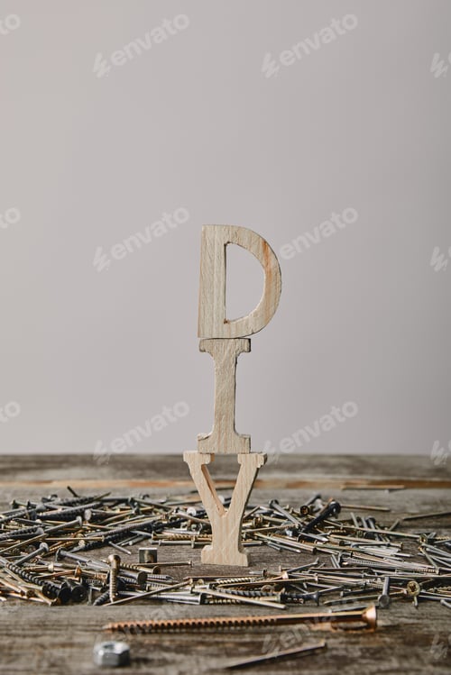 Preview: Close up of diy sign and nails on wooden table on grey background