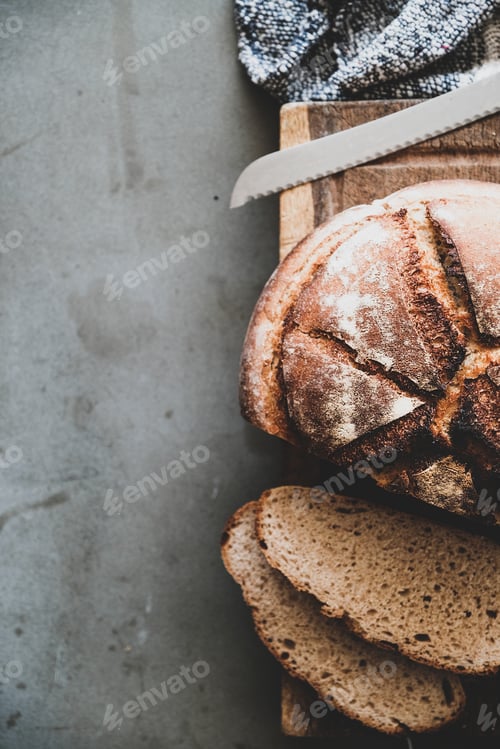 Preview: Freshly baked sourdough bread loaf and slices, vertical composition