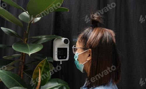 Preview: The Asian tourist woman has checked body temperature with a thermal Temperature scanner detector