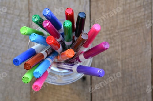 Preview: Overhead view of a container of bright colorful markers pens, office school supplies