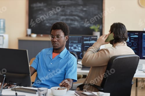 Preview: Young serious cyber security engineer looking at computer screen
