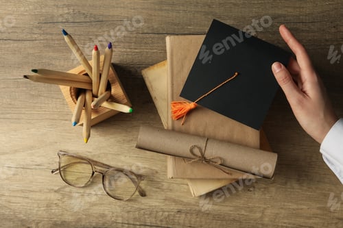 Preview: Graduate hat and books on wooden table