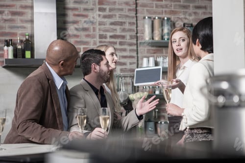 Preview: Friends with champagne glasses and tablet at home