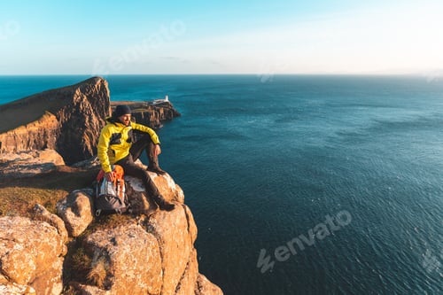 Preview: Man sitting on top of a cliff in Scotland