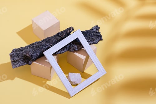 Preview: Modern abstract life style background: yellow cardboard, blank photo frame, stones, tree bark