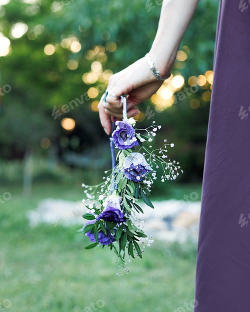 Preview: Woman Holding Purple Floral Arrangement in Green Field