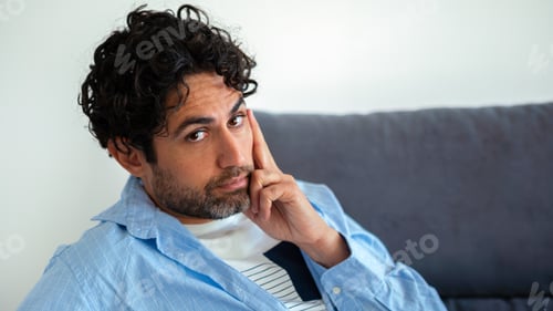 Preview: Portrait of cool and handsome man wearing a shirt and sitting on couch