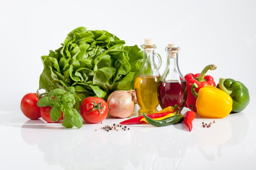 Preview: Lettuce with vinegar, olive oil, pepperonis, tomatoes and peppercorns on white background, close up
