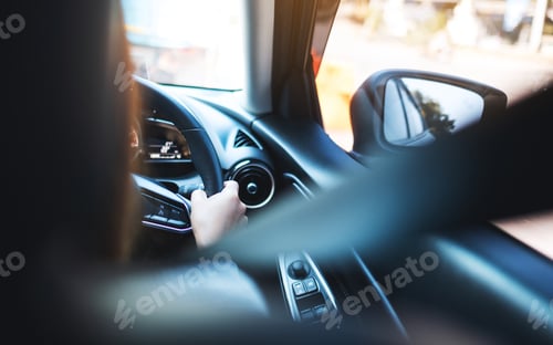 Preview: a woman holding steering wheel with seat belt fastened while driving a car on the road