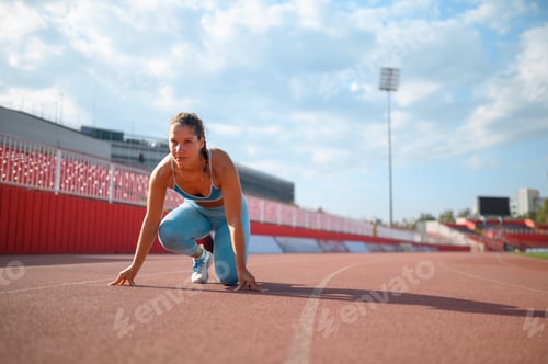 Preview: Portrait of a fitness woman preparing for a race on a tartan track at stadium
