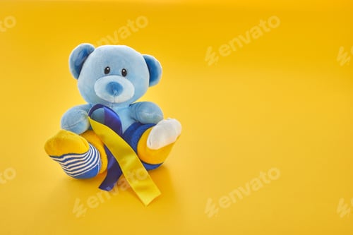 Preview: World Down Syndrome day background.Teddy bear with different socks on yellow background.