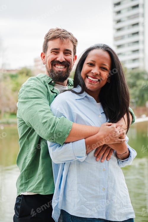 Preview: Vertical. Happy couple sharing a joyful embrace while smiling broadly at the camera with love