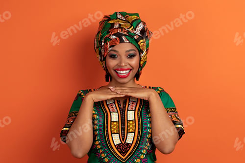 Preview: Cute beautiful young black woman posing on orange background