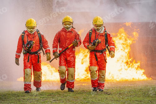 Vista previa: Three firefighters are walking through fire, one of them holding hose