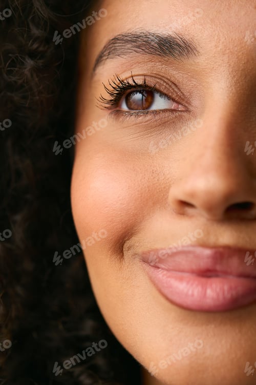 Preview: Close Up Studio Portrait Showing Half Face Of Smiling Natural Woman