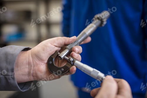 Preview: Hands using a micrometer to measure a metal part