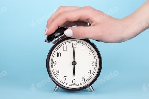 Preview: Female hand clamps the alarm clock