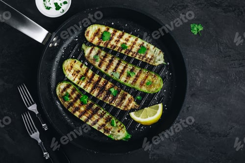 Preview: Grilled zucchini slices in cast iron pan on dark stone or concrete background
