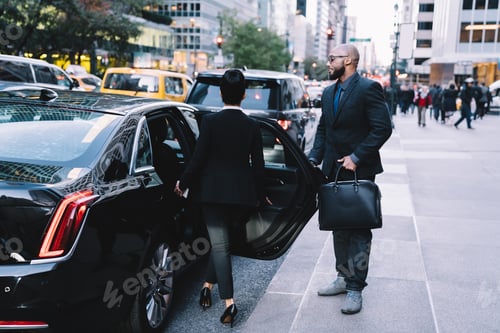 Preview: Successful business partners getting in car at city street