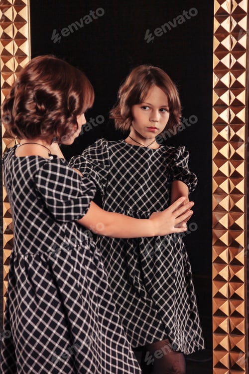 Preview: Portrait of pretty cute teenager girl in an elegant dress at mirror