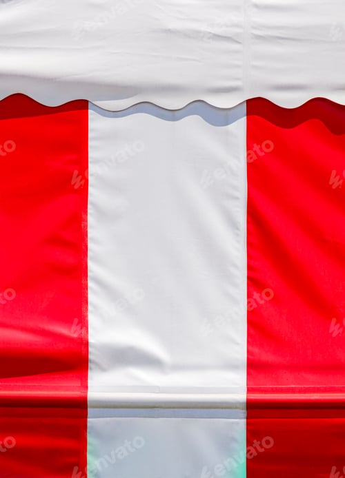 Preview: Sunlight on surface of red and white striped canvas awning and white roof tent in vertical frame
