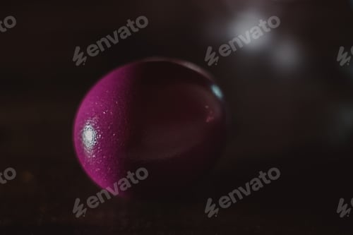 Preview: Chicken colored egg with drops of water on the surface on a mirror background
