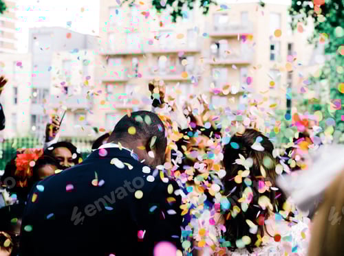 Preview: Confetti flying over the heads of a diverse couple on their wedding day.