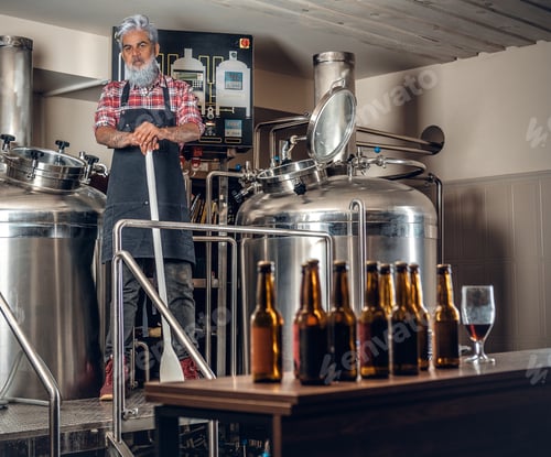 Preview: Grandfather brewer with long stick around huge barrel
