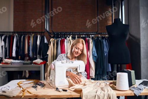 Preview: pleasant smiling woman decorating clothes with detailed embroidery work