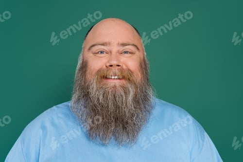 Preview: chubby and bald man with beard smiling at camera isolated on green