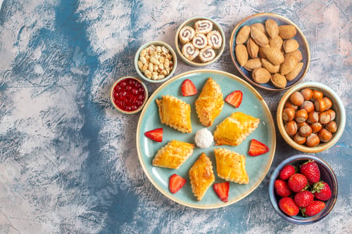 Preview: top view yummy sweet cakes with fruits and nuts on blue desk cake biscuit fruit sweet