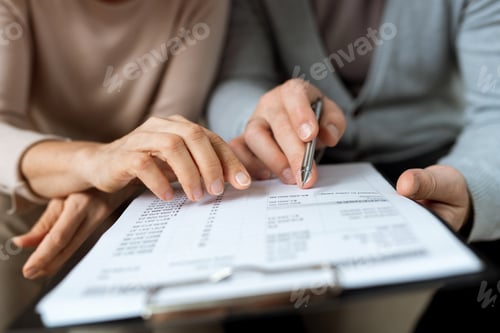 Preview: Two hands pointing at document while discussing terms and points of contract