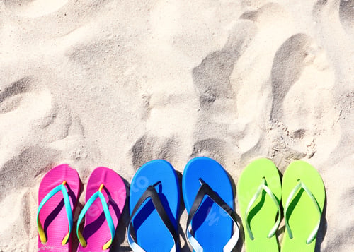 Preview: Flat lay composition with flip flops on sand in summer, space for text. Beach accessories