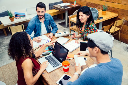 Preview: Four person multiethnic startup discussing ideas in the office