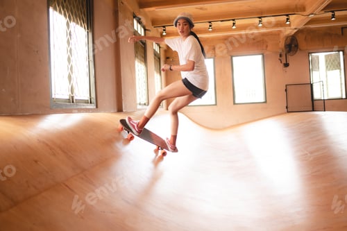 Preview: skater woman playing skateboard in sport gym, happy and fun with skateboarding lifestyle in city