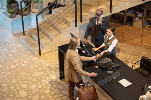 Preview: Group Discussing Work Assignment Near Desk in Office Setting