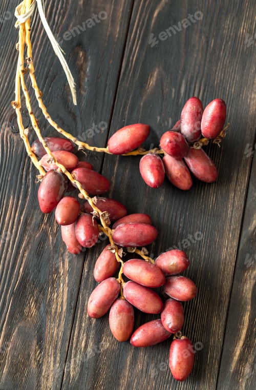 Preview: Branch of dates on the wooden background