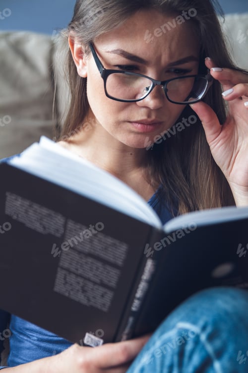 Preview: A woman with vision problems is reading a book with glasses.