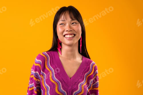 Preview: happy asian woman smiling wearing colorful sweater and lightning bolt earrings