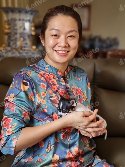 Preview: Portrait of an Asian woman holding her cute pet chihuahua puppy
