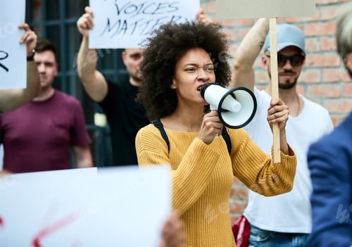 Preview: African American woman shouting through megaphone on anti-racism protest.