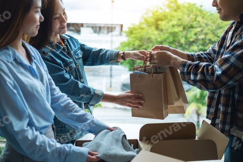 Preview: Women receive shopping bags form delivery man at home