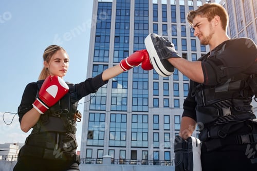 Preview: two young people training with boxing gloves on the street