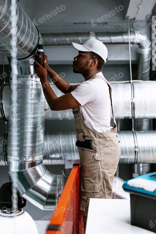 Preview: Professional worker repairing ventilation system in commercial building during daytime