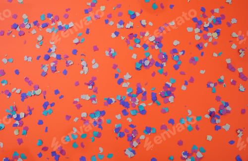 Preview: Confetti colorful scattered on orange background. Carnival party, invitation card. Overhead view.