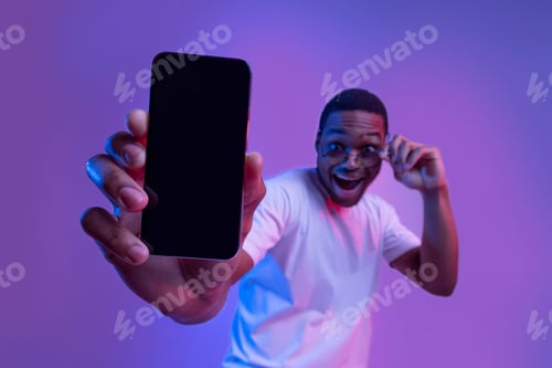 Preview: Cool App. Smartphone With Black Screen In Hand Of Excited African Guy