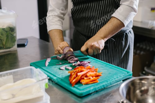 Preview: Close up, male chef cuts vegetables in restaurant.