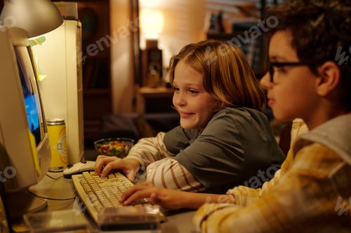 Preview: Siblings Playing Computer Game in Cozy Room